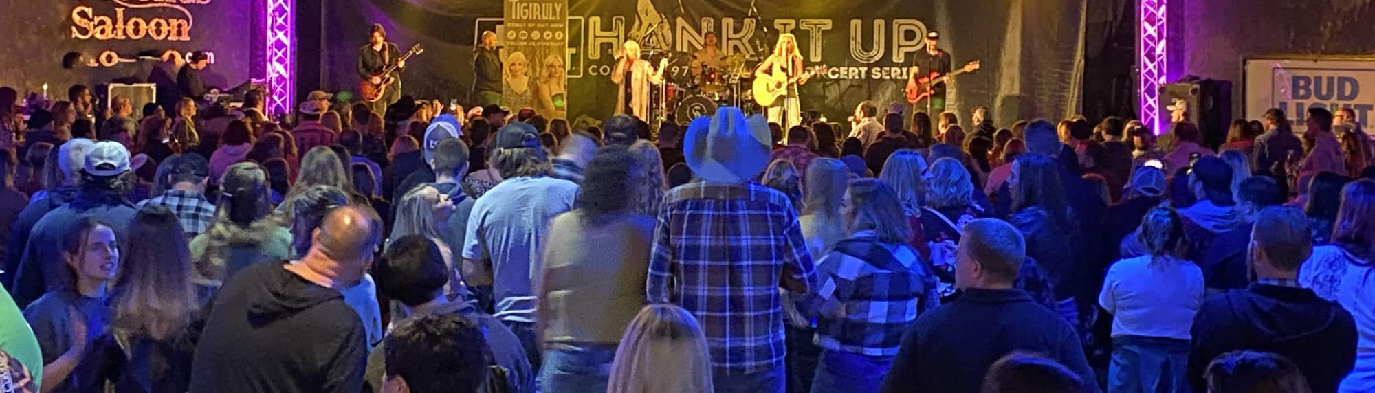 country concert with fans wearing cowboy hats Fayetteville