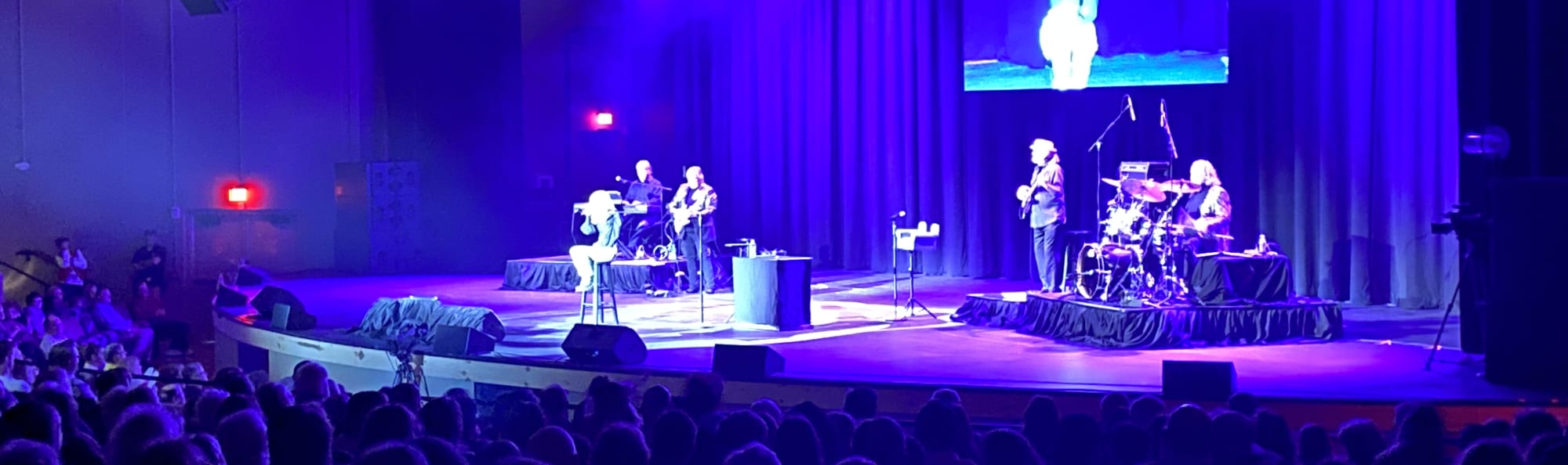 signer on stage in chair washed out by the lights Fayetteville